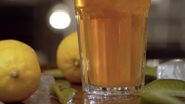 把杯子和冰茶放在桌子上 合拢手 杯子与冰茶或鸡尾酒 柠檬和叶子在桌子上的模糊灯光背景 酒吧柜台关门 — 图库视频影像