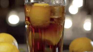 Long Island buzlu çayını bardağa karıştırıp saman içerek kapat. Köpüklü içecek, viski ya da romlu kokteyl ya da bulanık ışık arka planında bir masada kola. Bar tezgahına yakın çekim. Buz gibi içecek.