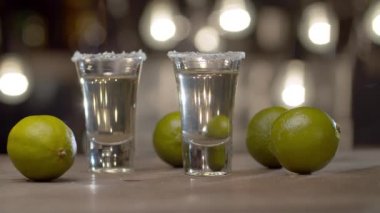 İki bardağı yanan tekilayla kapat. Sert alkollü içki ve limonlu Stemware. Bulanık ampullerin arkaplanındaki çubuk sayacı.