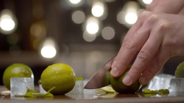 Close Male Hand Slicing Lime Table Background Blurry Light Bulbs — Stock Video