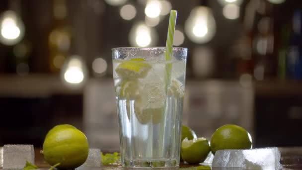 Cierre Tónico Agua Soda Vaso Con Cal Hielo Sobre Mesa — Vídeo de stock