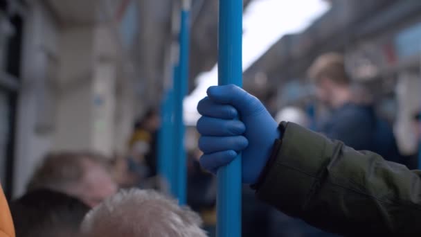 Hand in beschermende handschoen houdt handgreep in metro auto — Stockvideo