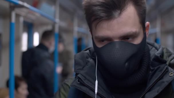 Человек в вагоне метро с наушниками — стоковое видео