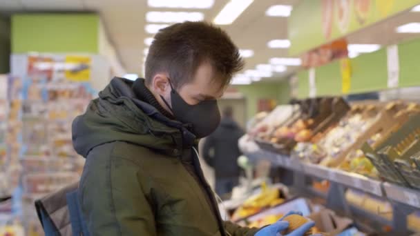 Мужчина выбирает киви в супермаркете — стоковое видео