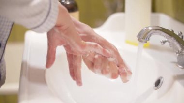 Kadın ellerini titizlikle yıkıyor.