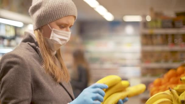 Mujer eligiendo plátano en el supermercado — Vídeo de stock