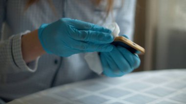 El temizleme akıllı telefonu dezenfektan peçeteyle.