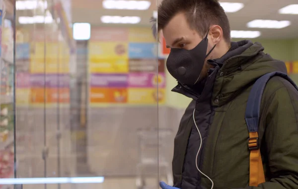 Человек Защитной Маске Перчатках Выбирает Еду Супермаркете Эпидемия Коронавируса Городе — стоковое фото