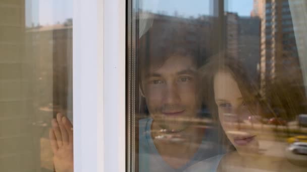 Молодая счастливая пара стреляет в окно — стоковое видео