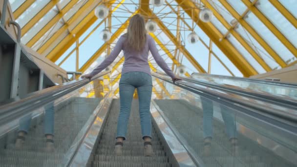 Jeune femme debout sur l'escalier roulant — Video