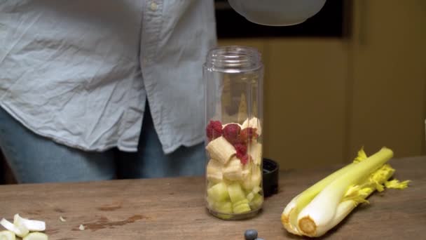 Frau gießt Himbeeren in Mixerglas — Stockvideo