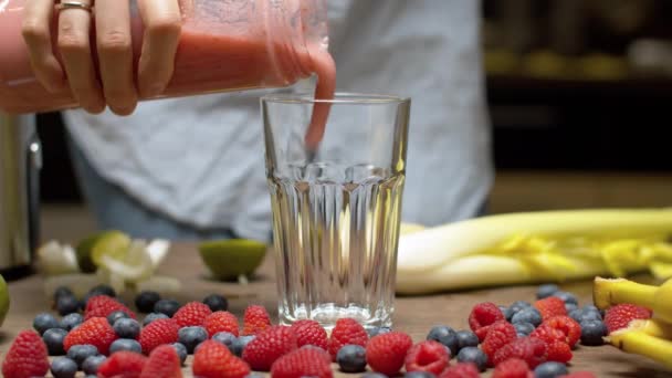 Frau gießt Smoothies ins Glas — Stockvideo