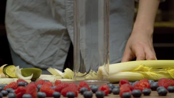 Vrouw die gehakt selderij in een blender glas — Stockvideo