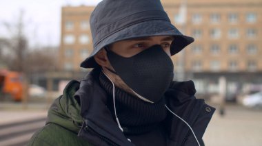 Yeniden kullanılabilir yüz koruyucu maskeli genç bir adamın açık havada çekilmiş portresi. Moskova 'da koronavirüs salgını. Sağlık ve güvenlik kavramı. COVID-19 salgını