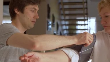 Oğlu evde yaşlı bir annenin tansiyonunu ölçüyor. Genç adam, yaşlı kadının nabız ölçer kullanarak basıncı kontrol etmesine yardım ediyor. Sağlık hizmetleri kavramı