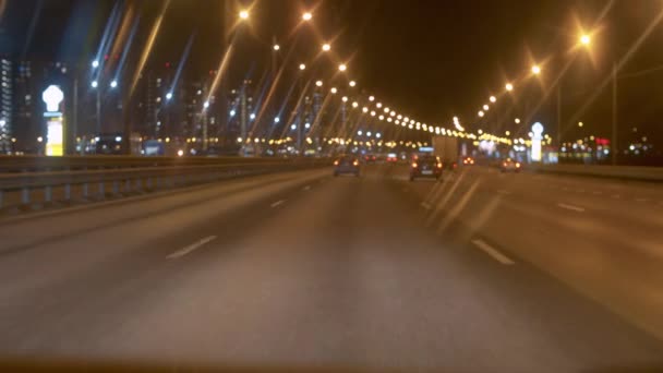 移動車のフロントガラスを介して夜の高速道路 夜景の運転ポイント Pov 車のぼやけた光 車輪の下で実行されている道路 — ストック動画