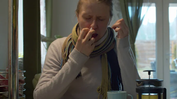 Больной женщиной с помощью носового спрея — стоковое фото