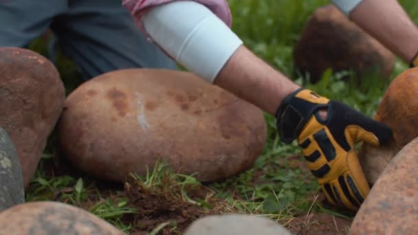 Yands człowieka rzucającego kamienie w kole — Wideo stockowe