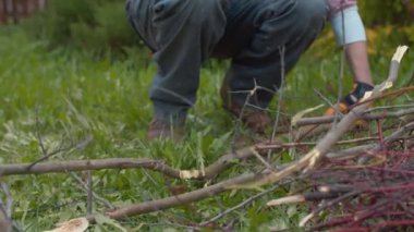 Şenlik ateşi için ağaç dalını baltayla kesen adam.