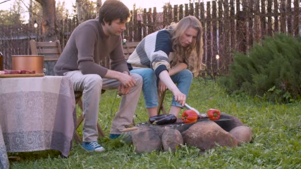 Casal assar carne na churrasqueira ao ar livre — Vídeo de Stock