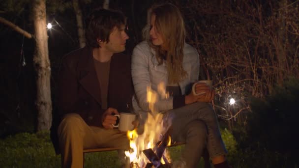 Jovem família à noite sentado perto da fogueira — Vídeo de Stock
