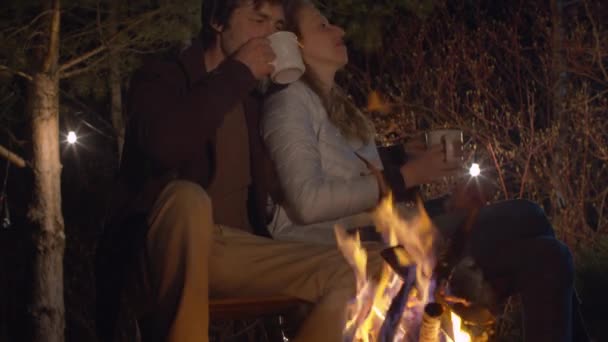 Jovem casal à noite abraçando perto da fogueira — Vídeo de Stock