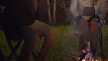 Aile ateşin yanına oturur ve ellerini ısıtır.