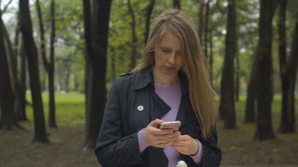 Mulher olhando no telefone inteligente e sorrindo — Vídeo de Stock