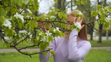Çiçeklenmiş elma ağacının yanında mutlu bir kadın