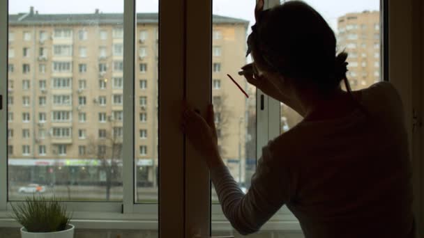 Женщина пишет на окне с губной помадой — стоковое видео