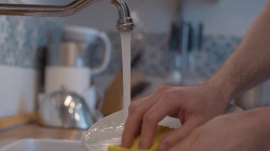 Bulaşık yıkayan genç adamın elleri