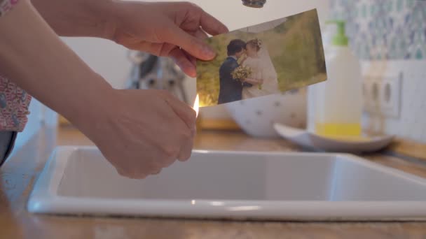 Female hands burning a wedding photo — Stock Video