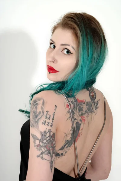 Beautiful tattooed woman with red lipstick isolated on white