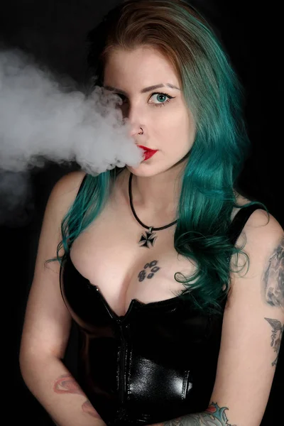 Hermosa mujer tatuada con lápiz labial rojo fumando Imagen De Stock