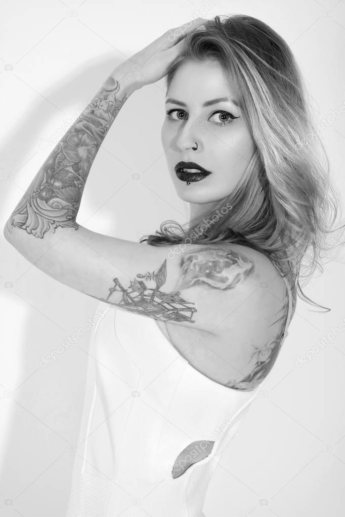 Beautiful tattooed woman with red lipstick isolated on white