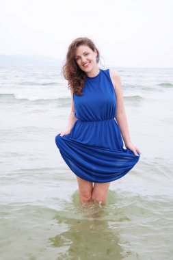 Sahilde mavi elbiseli genç kadın