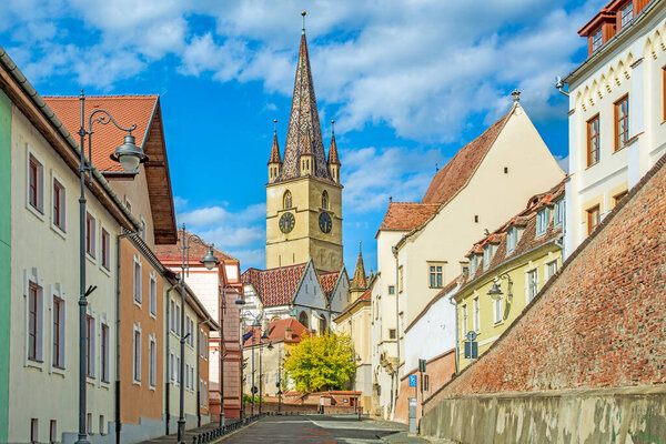 Sibiu, Transylvania, Romania, street in old town and tower gothic lutheran cathedral from XIV century
