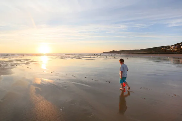 Pojke gå ensam på woolacombe beach på kvällen — Stockfoto