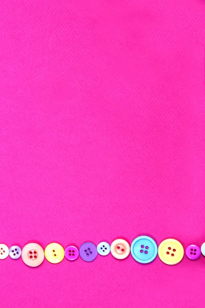 Single lines of buttons on a pink paper background — Stock Photo, Image