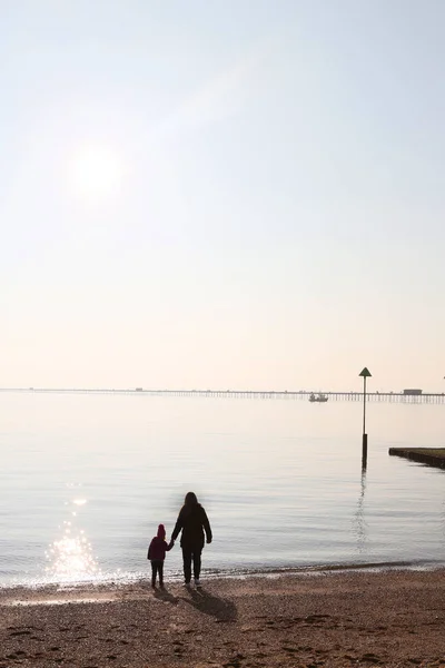 큰 해변에서 작은 규모로 손을 잡고 있는 어머니와 아이 — 스톡 사진