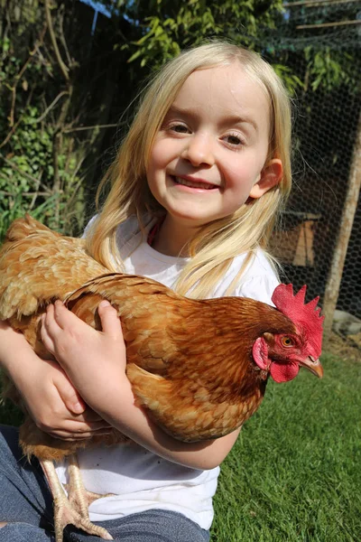 Little girl holding her pet chicken — Stock Photo, Image