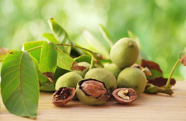 Branch of walnuts on table — Stock Photo, Image
