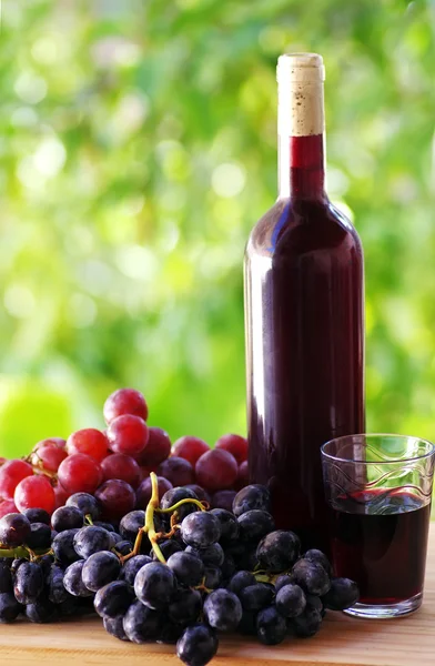 Uvas maduras, copa de vino y botella de vino — Foto de Stock