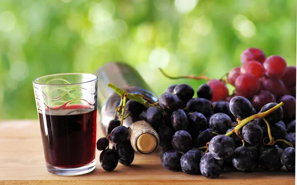 Uvas e vinho tinto na mesa — Fotografia de Stock