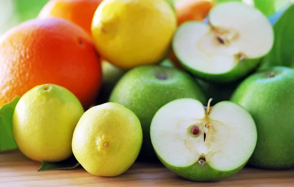 Свежие спелые фрукты апельсин, лимон, яблоко на столе — стоковое фото
