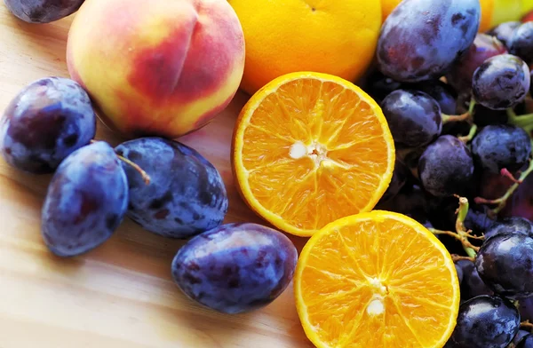 Closeup of orange slices, peaches, grapes and plums — Stock fotografie