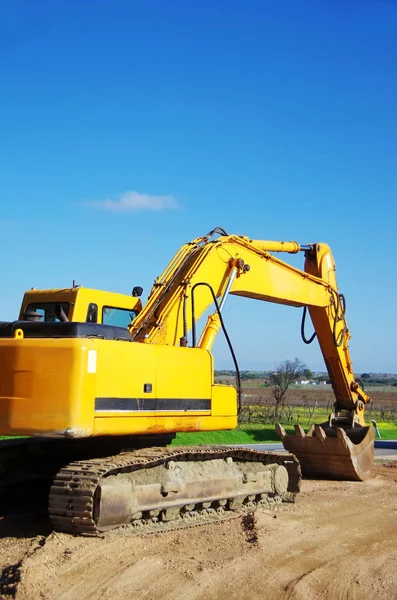 Yellow excavator on field — Stock Photo, Image