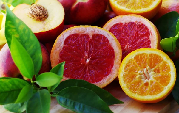 新鲜的葡萄柚和木制的桌子上片橙色 — 图库照片