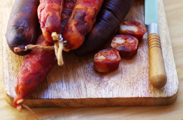 Portuguese sausage chourico and knife on table — Stock Photo, Image