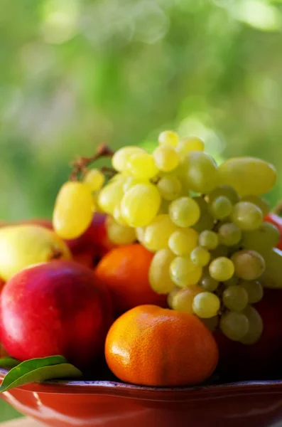 Cesta llena de frutas frescas, peras, melocotones, mandarina y uva —  Fotos de Stock